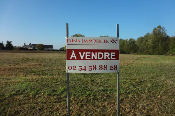 Panneau à vendre sur un terrain à bâtir